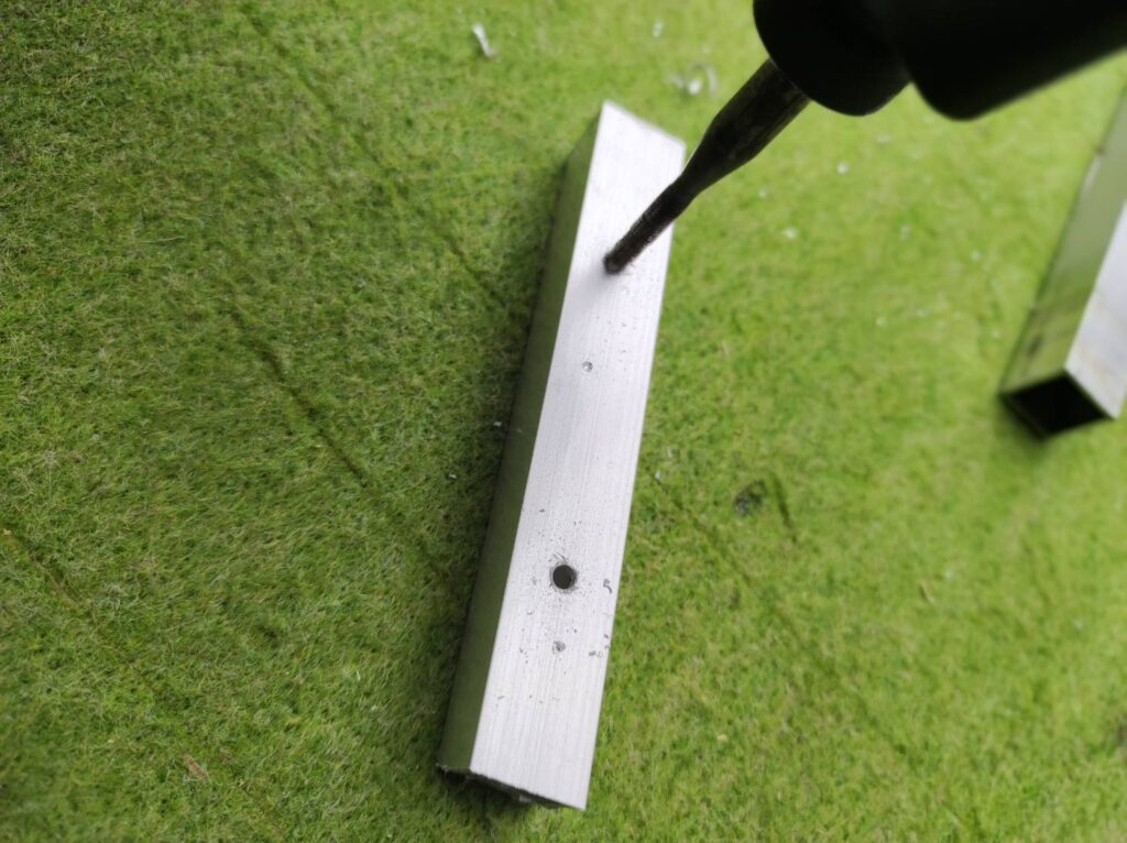 裏板にクレセント錠用のネジ穴加工を行っている様子