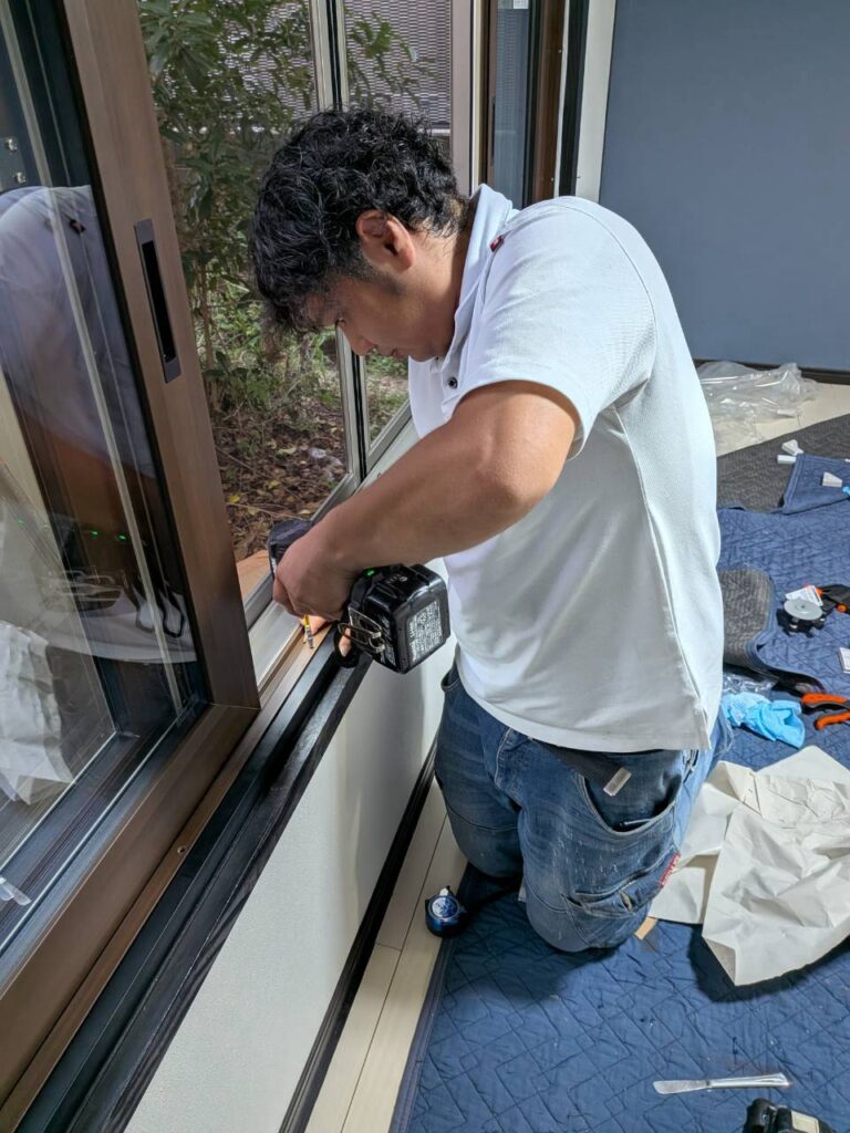 窓まわりを仕上げる樹脂額縁の取り付け作業
