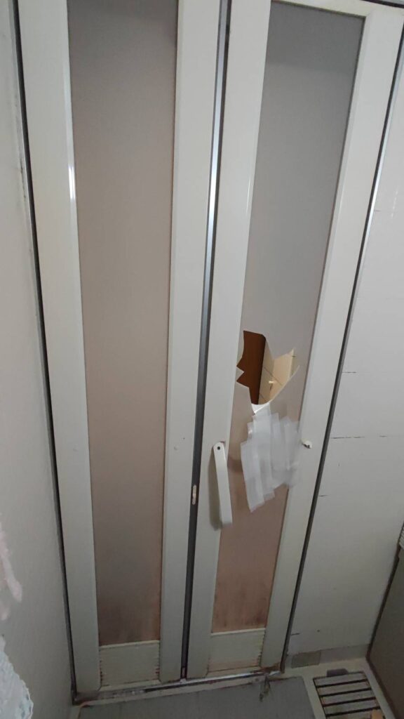 下関市で浴室ドアの破損状態を確認している施工前写真