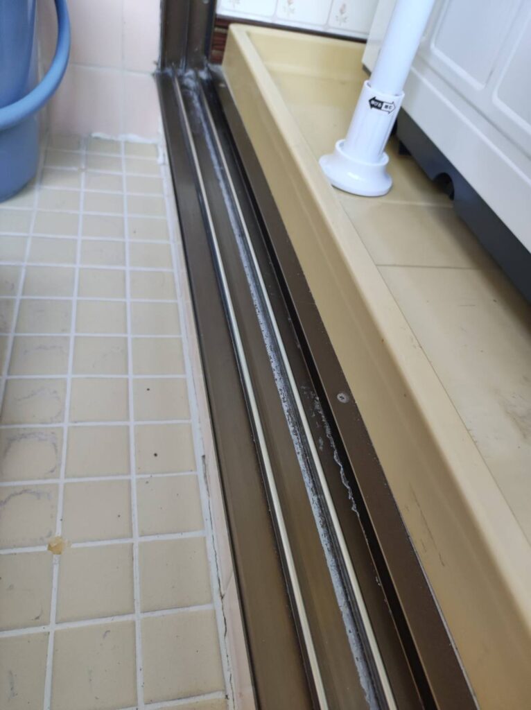削れてガタついた浴室引き戸レールの状態