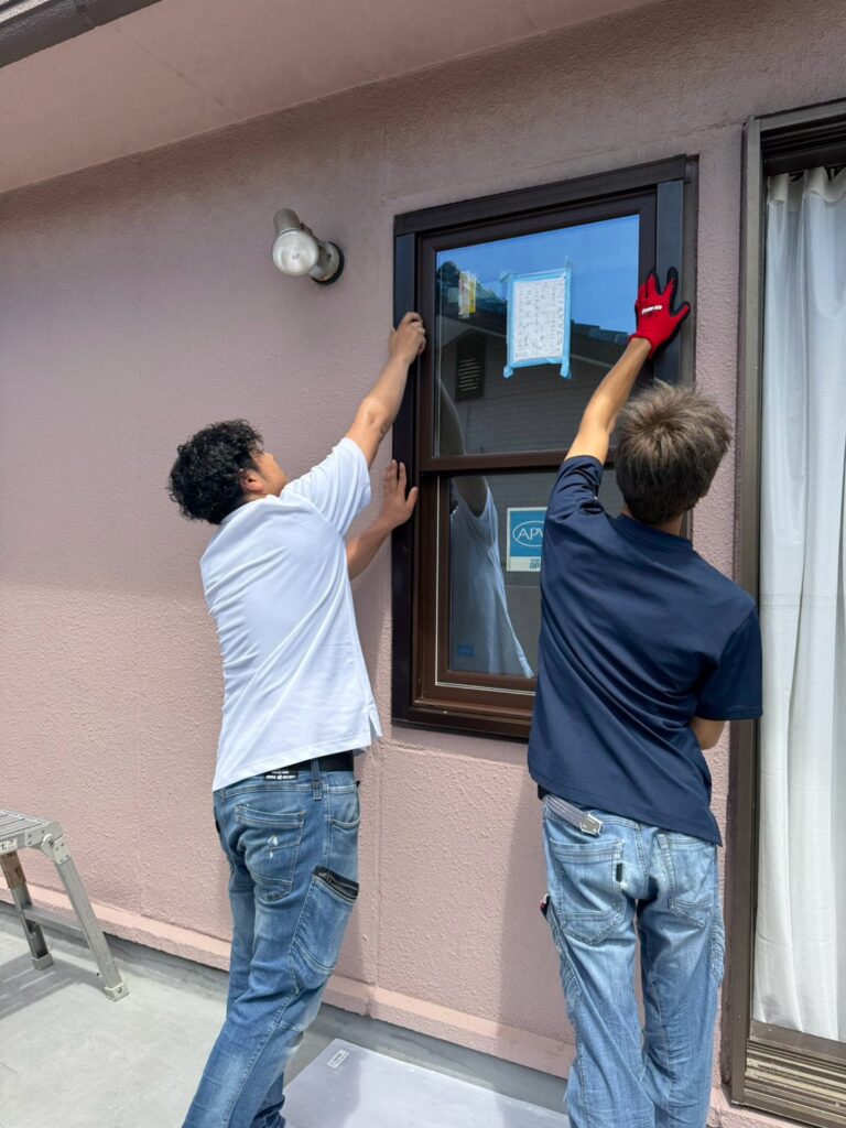室外側からマドリモ片上げ下げ窓を既設枠へはめ込む様子
