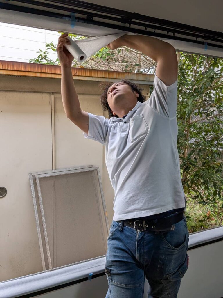 既存の障子を撤去して窓枠まわりに気密シートを貼り付けている様子