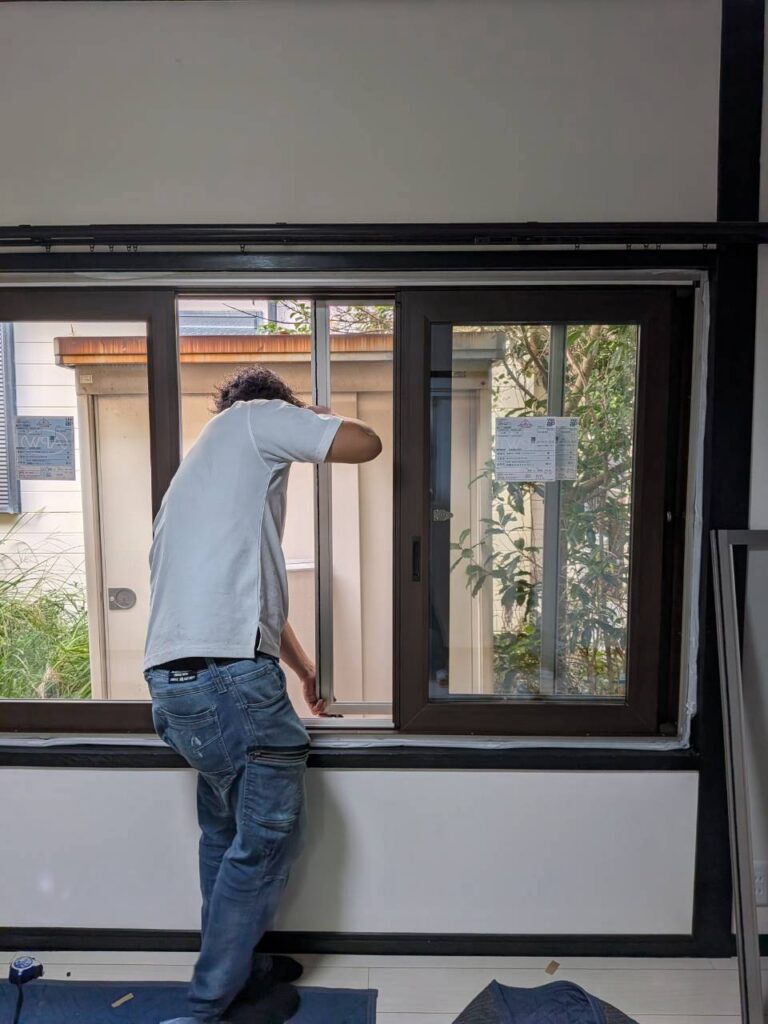 新しい4枚建引違い窓に網戸を取り付けている様子