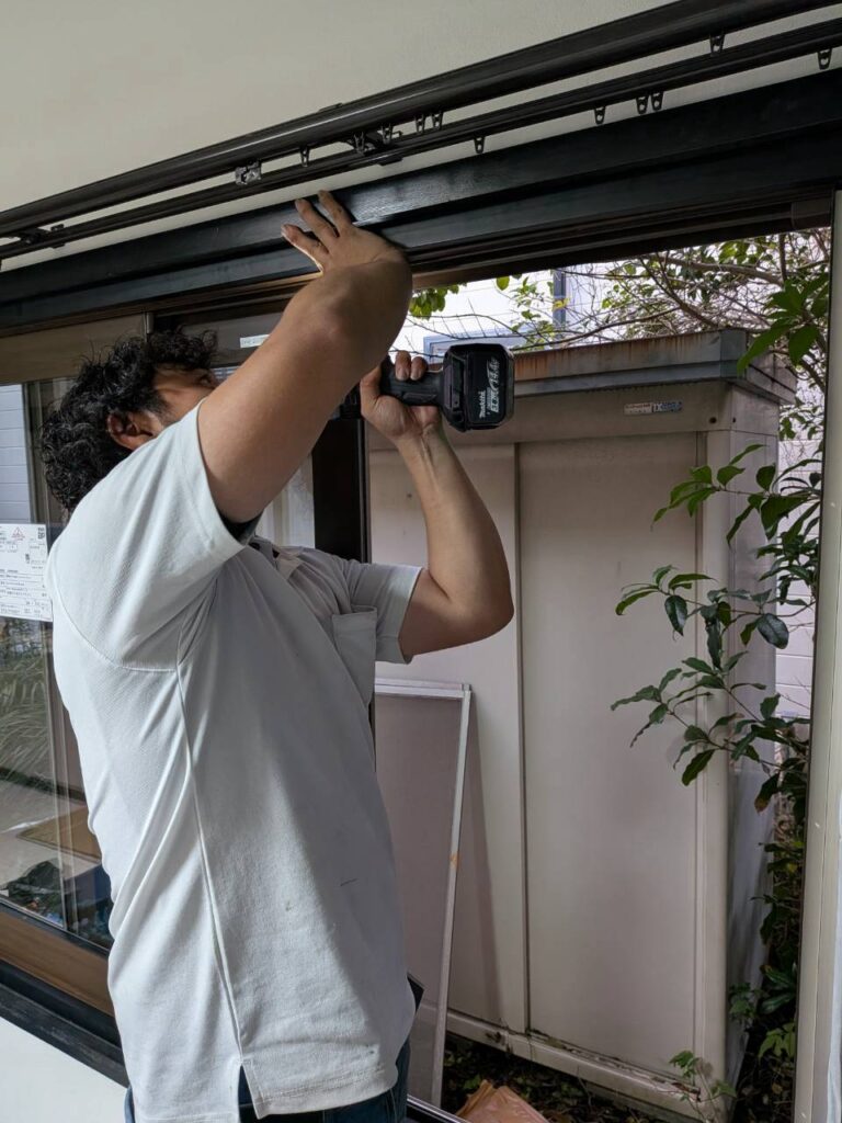 室内側の既存枠を覆う樹脂額縁を取り付けている様子