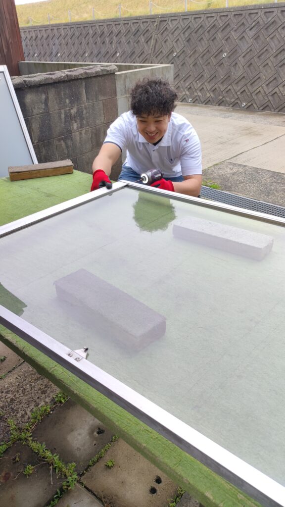 サッシの施工中に笑顔を見せるMADOSUKE代表・寺川幸希